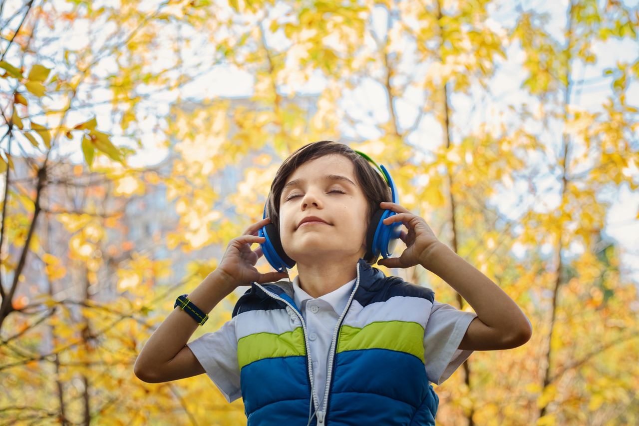 A listener wearing headphones outdoors